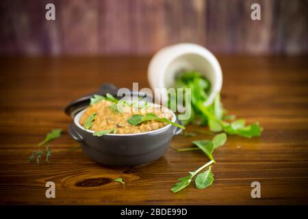 Gekochte Bulgur grobelt mit Gemüse und Kräutern in einer Keramikschale Stockfoto