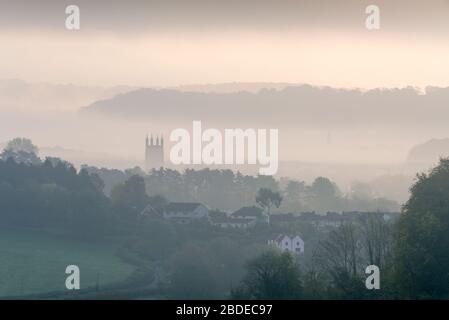 Morgennebel über der Stadt Wells und dem Turm der St. Cuthebert's Kirche vom Ebbor Gorge National Nature Reserve in den Mendip Hills, Somerset, England aus gesehen. Stockfoto