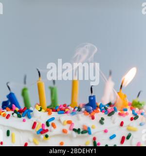 Erloschene Geburtstagskerzen auf Kuchen - eine noch brennend Stockfoto
