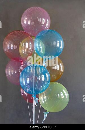 Große bunte Ballons auf dem grauen Hintergrund Stockfoto