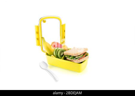 Gesundes gelbes Mittagessen mit Sandwiches und Obst für Kinder. Mit einem spork auf der Seite. Stockfoto