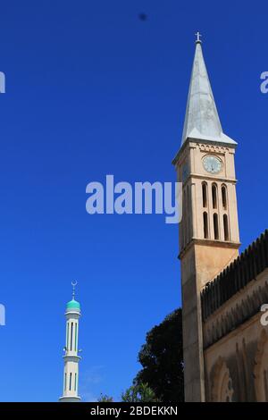 Anglikanischer Domturm mit einem Moschee-Minarett im Hintergrund, Stone Town, Sansibar Stockfoto