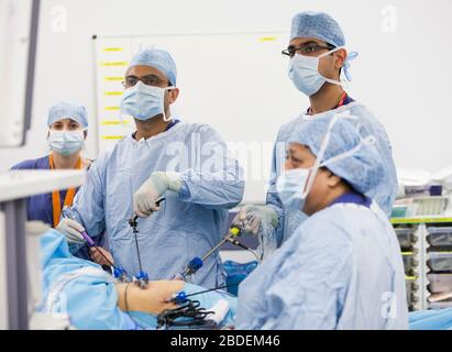 Chirurgen und Krankenschwestern führen eine laparaskopische Magenoperation in einem NHS-Krankenhaus durch. Die NHS steht wegen der Unterfinanzierung durch die Regierung unter Druck. Stockfoto