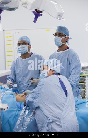 Chirurgen und Krankenschwestern führen eine laparaskopische Magenoperation in einem NHS-Krankenhaus durch. Die NHS steht wegen der Unterfinanzierung durch die Regierung unter Druck. Stockfoto