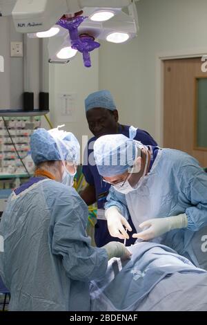 Chirurgen und Krankenschwestern führen eine Magenoperation in einem NHS-Krankenhaus durch. Die NHS steht wegen der Unterfinanzierung durch die Regierung unter Druck. Stockfoto