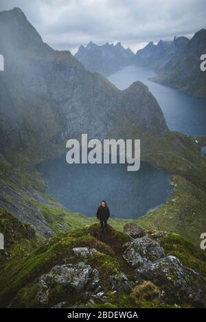 Norwegen, Lofoten Islands, reine, man auf Reinebringen mit See und Fjord im Hintergrund Stockfoto