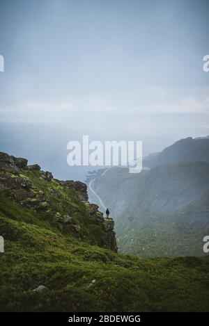 Norwegen, Lofoten Islands, reine, man Blick auf den Berg fromÂ ReinebringenÂ bei Regen Stockfoto