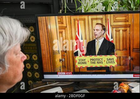 Dominic Raab, erster Staatssekretär, gab eine Fernseh-Pressekonferenz zu Covid-19; von einem älteren Zuschauer beobachtet. Stockfoto