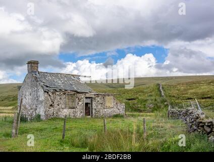 Ein aus Stein gebautes Bauernhaus in der malerischen Yorkshire Dales mit einem bewölkten Himmel. Stockfoto