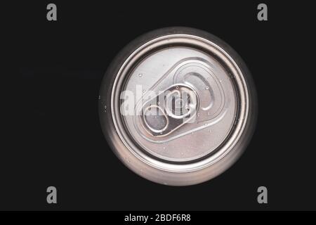 Metall-Soda-Dose mit Wassertropfen auf schwarzem Hintergrund. Draufsicht auf ein Bier aus Aluminium. Metallischer Getränkebehälter, Getränk. Runde Stahloberfläche Stockfoto