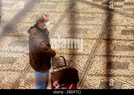 Olhão, Portugal, 8. April 2020. Menschen tragen Masken, Handschuhe und halten einen sicheren Abstand als Schutzmittel und halten den Ausbruch des COVID-19 ein. Stockfoto