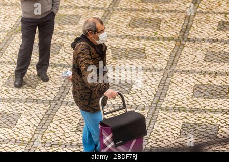 Olhão, Portugal, 8. April 2020. Menschen tragen Masken, Handschuhe und halten einen sicheren Abstand als Schutzmittel und halten den Ausbruch des COVID-19 ein. Stockfoto