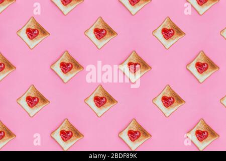 Geröstete Brotscheiben mit herzförmigem Gelee oben. Stockfoto