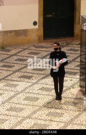 Olhão, Portugal, 8. April 2020. Menschen tragen Masken, Handschuhe und halten einen sicheren Abstand als Schutzmittel und halten den Ausbruch des COVID-19 ein. Stockfoto