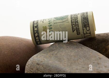 Die US-Dollar-Währung auf den Flussfelsen spiegelt konzeptuelle Abgänge und depressive Investitionswerte wider Stockfoto