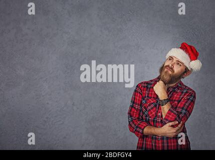 Bärtiger Mann denkt nach weihnachtsgeschenk-ideen isoliert grauen Hintergrund Stockfoto