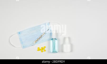 Schutzmaske, Antiseptikum, Thermometer und Pillen, flacher Lay. Konzept von Ärztetabelle und Gesundheitswesen. Draufsicht, Kopierbereich Stockfoto