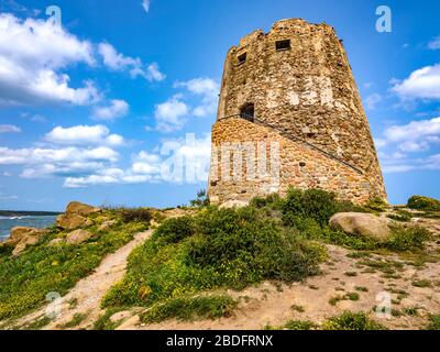 Nahaufnahme von 'Torre di Barì', einem Turm auf einem Felsvorsprung am Strand mit beigem Sand und Meer mit kristallklarem Wasser, Bari Sardo, Sardinien, Italien Stockfoto