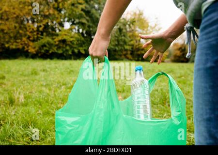 Frau betufft weiche Kunststoffabfälle in große Plastikflaschen, um einen Ökobrick herzustellen, der dann als Bruderblock verwendet werden kann Stockfoto