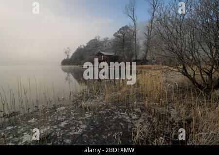 Bootshaus am Ullswater an einem nebligen Wintermorgen, in der Nähe der Pooley Bridge, Cumbria, Großbritannien. Stockfoto