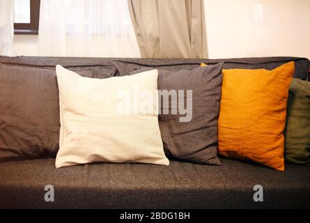 Wohnzimmer mit grauem Sofa und gelben Kissen. Gemütlicher Hintergrund Stockfoto