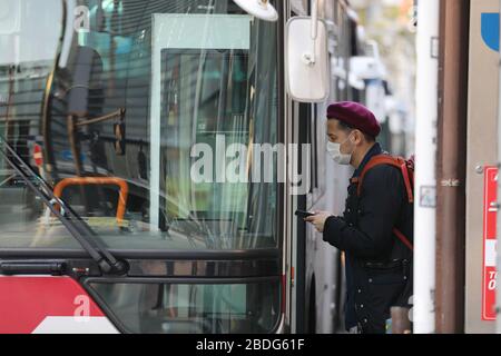 Tokio, Japan. April 2020. Eine Tragemaske für Passagiere steigt am 8. April 2020 in Shinagawa-ku, Tokio, Japan, in einen Bus ein. Japanische Großstädte, einschließlich der Hauptstadt Tokios, wurden am Mittwoch ungewöhnlich ruhig, da viele Geschäfte geschlossen waren und am ersten Tag nach dem Ausrufung des Ausnahmezustands weniger Menschen auf Straßen waren, um die schnelle Ausbreitung von COVID-19-Infektionen im ganzen Land zu begrenzen. Credit: Du Xiaoyi/Xinhua/Alamy Live News Stockfoto