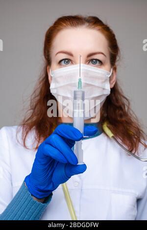 Mit Impfstoff gefüllter Spritze, gegen Coronavirus kämpfend. Stockfoto