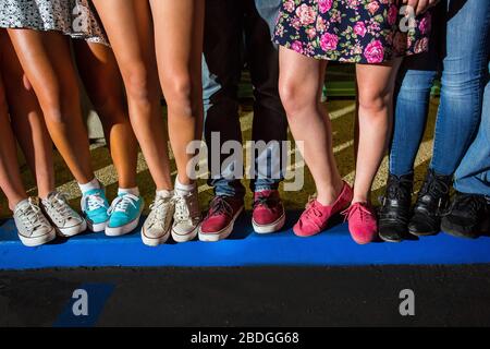 Junge Erwachsene Beine und Füße stehen zusammen auf einer blauen Kerb Stockfoto