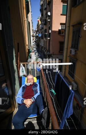 Neapel, Italien. April 2020. Ein Mann ruht in der Sonne auf einem Balkon mit Schutzmaske im spanischen Viertel (Quartieri Spagnoli) in der Innenstadt. In Italien wird der Sperrverfall weiterhin durch Regierungsdekret erklärt, das ganz Italien zu einem Schutzgebiet zur Bekämpfung der Kovidinfektion 19 erklärt - Coronavirus-Infektion, Schließung von Schulen, öffentlichen Büros und Geschäften. Kredit: Unabhängige Foto-Agentur Srl/Alamy Live News Stockfoto