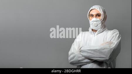 Coronavirus Kovid-19-Desinfektion. Portrait kaukasischer Arzt im medizinischen Schutzanzug, biologische Gefahr, medizinische Maske FFP3, Schutzbrille auf grau isoliert Stockfoto