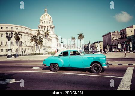 HAVANNA, KUBA - 10. DEZEMBER 2019: Farbige klassische amerikanische Autos, die als Taxis dienen, fahren auf der Hauptstraße vor dem Kapitolio-Gebäude i vorbei Stockfoto