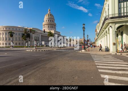 HAVANNA, KUBA - 10. DEZEMBER 2019: Farbige klassische amerikanische Autos, die als Taxis dienen, fahren auf der Hauptstraße vor dem Kapitolio-Gebäude i vorbei Stockfoto