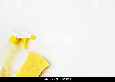 Reinigungsmittel in einer Sprühflasche. Flaches Lay aus antibakteriellem Produkt und gelbem Schwamm auf weißem Hintergrund. Nahaufnahme. Kopierbereich. Stockfoto