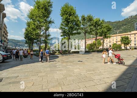 Como, ITALIEN - 4. August 2019: Lokale Menschen und Touristen in einer ruhigen, gemütlichen Straße im Zentrum der schönen italienischen Comer Stadt. Warm sonniger Sommertag in Stockfoto