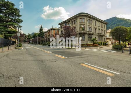 Como, ITALIEN - 4. August 2019: Lokale Menschen und Touristen in einer ruhigen, gemütlichen Straße im Zentrum der schönen italienischen Comer Stadt. Warm sonniger Sommertag in Stockfoto