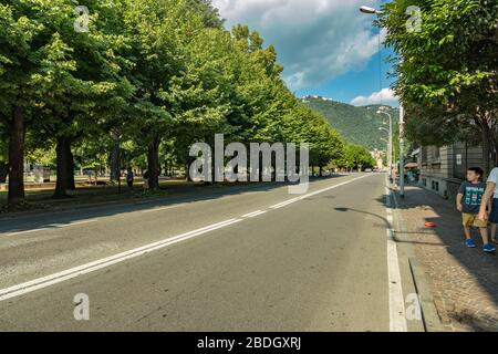 Como, ITALIEN - 4. August 2019: Lokale Menschen und Touristen in einer ruhigen, gemütlichen Straße im Zentrum der schönen italienischen Comer Stadt. Warm sonniger Sommertag in Stockfoto