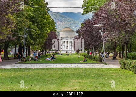 Como, ITALIEN - 4. August 2019: Lokale Menschen und Touristen auf der Viale Guglielmo Marconi in der Nähe des Comer Sees. Tempio Voltiano Museum im Hintergrund. Warme sonne Stockfoto