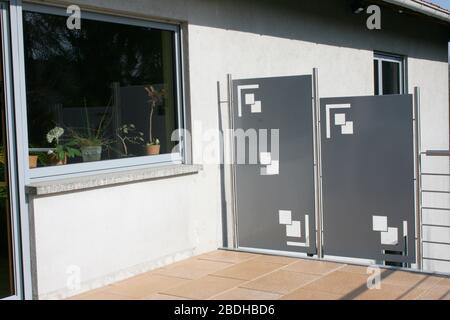 Eine Terrasse mit Edelstahlgeländer und beigefarbenen Bodenfliesen eine Terrasse mit Edelstahlgeländer und beigen Bodenplatten Stockfoto