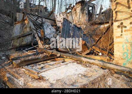 Altes zerbrochenes Fenster, das auf dem Boden lag, nachdem das verlassene Haus niedergebrannt war Stockfoto