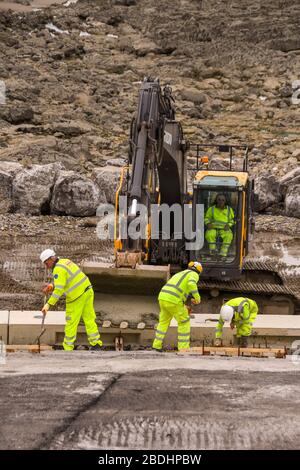 PORTHCAWL, WALES - JUNI 2018: Bauarbeiter arbeiten an der Sanierung der Strandpromenade im Zentrum der Stadt. Stockfoto