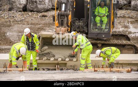 PORTHCAWL, WALES - JUNI 2018: Bauarbeiter arbeiten an der Umgestaltung der Küste im Zentrum der Stadtpromenade Stockfoto