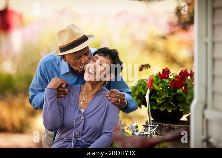 Senior küsst seine Frau mit Nasenkanüle auf die Wange. Stockfoto