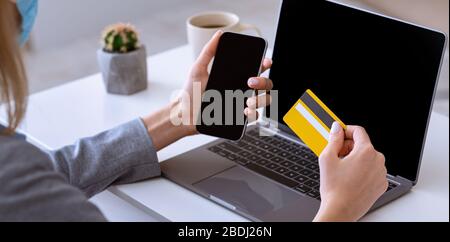 Online-Shopping von zu Hause aus. Mädchen hält Smartphone und Kreditkarte Stockfoto