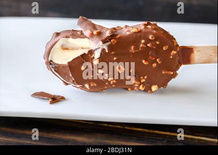 Schokoladenbedeckter Vanilleeis auf der weißen Platte Stockfoto