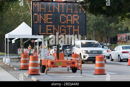 Ein Schild weist die Fahrzeuge an, die soziale Distanz zu einer mobilen Teststation COVID-19 im South County Civic Center am 7. April 2020 in Delray Beach, Florida zu halten. Stockfoto