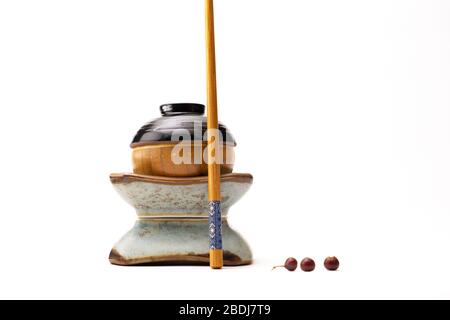 Ein Stillleben einer japanischen Figur, die aus Tassen und einem auf weißem Hintergrund isolierten Essstäbchen gebaut wurde Stockfoto