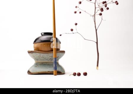 Ein Stillleben einer japanischen Figur, die aus Tassen und einem auf weißem Hintergrund isolierten Essstäbchen gebaut wurde Stockfoto