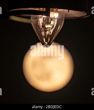 Frankfurt, Deutschland. April 2020. 08. April 2020, Hessen, Frankfurt am Main: Der Mond ist am Abend unter einer Gaslaterne im Stadtteil Seckbach zu sehen. Credit: Dpa Picture Alliance / Alamy Live News Stockfoto