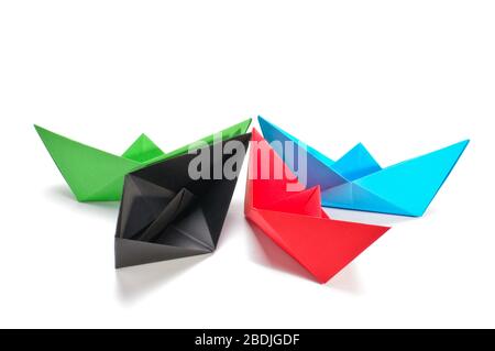 Grüne, schwarze, rote und blaue Papierschiffseite isoliert auf dem weißen Stockfoto