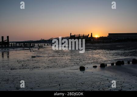 Sonnenuntergang hinter dem Strand bei Climping bei Ebbe. Stockfoto